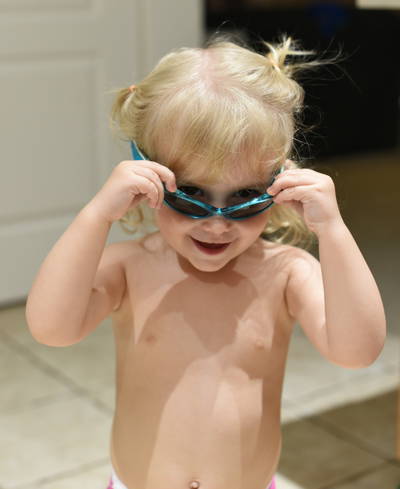 Priya wearing goggles in bright kitchen
