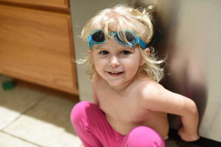 Priya wearing goggles by dishwasher