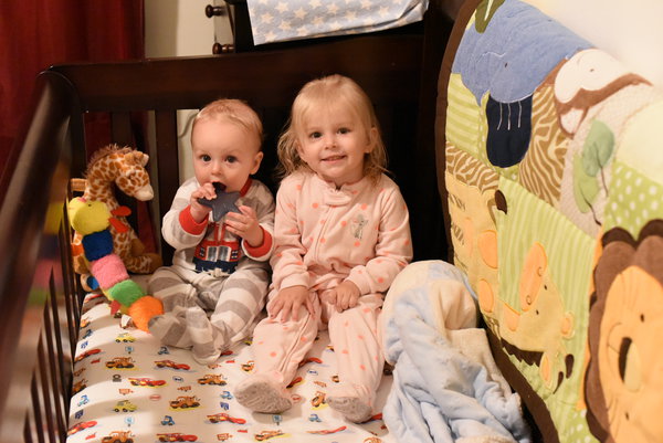 Remy and Priya sitting in crib