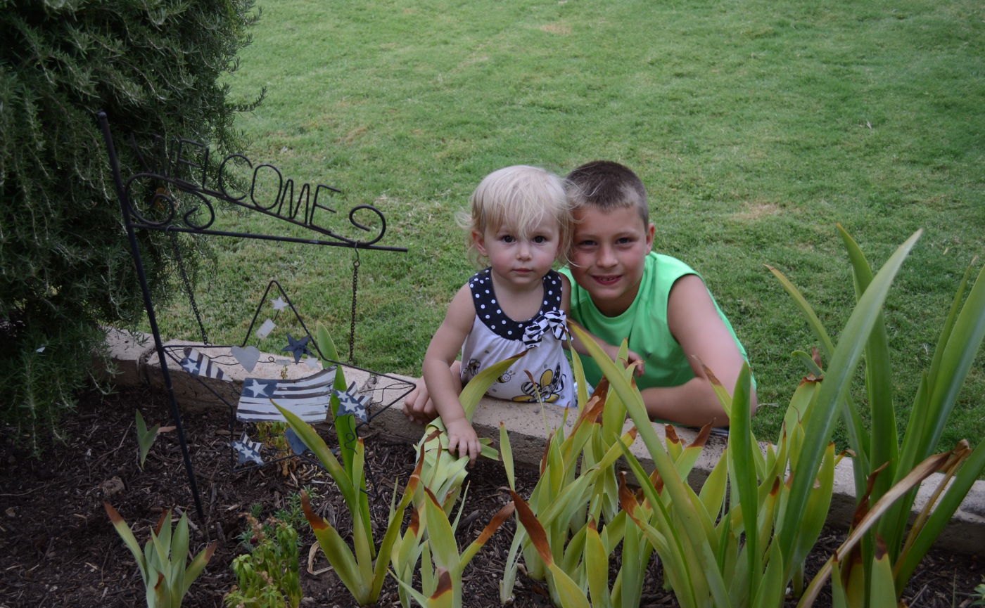 Priya and Ben sitting at flower bed